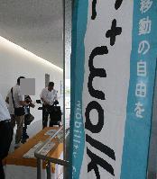 歩道での移動をアシストする移動用小型車の展示および試乗を体験する参加者の写真