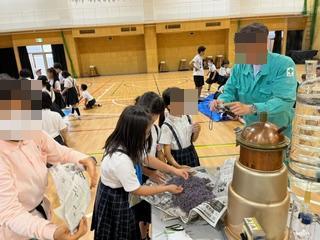 令和6年6月24日南松尾はつが野学園3年生の児童がラベンダーを蒸留器の前に運ぶ様子