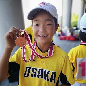 メダルを持つ玉置さん