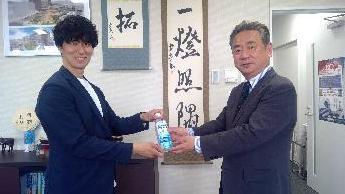 大槻教育長がマクドナルド株式会社フランチャイジー 株式会社フルグラッド 代表取締役 半田裕也様から経口補水液を受け取っている写真