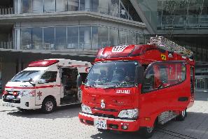屋外に展示されている、消防車両やドアが開放されて内部も見える救急車両の写真