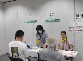保健所コーナーでストレスチェックやお酒の飲み方チェック等を受けている来場者たちの写真
