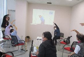 地域包括支援センターコーナーで、いきいきいずみ体操に参加している市民の写真