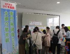 大阪介護支援専門員協会和泉支部のコーナーでパネル展示をみる来場者たちの写真