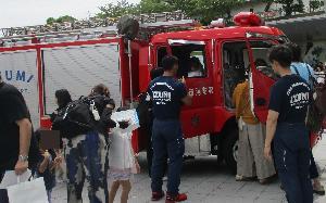 屋外に展示されている消防車両の内部を見たり、車内に入っている参加者の写真
