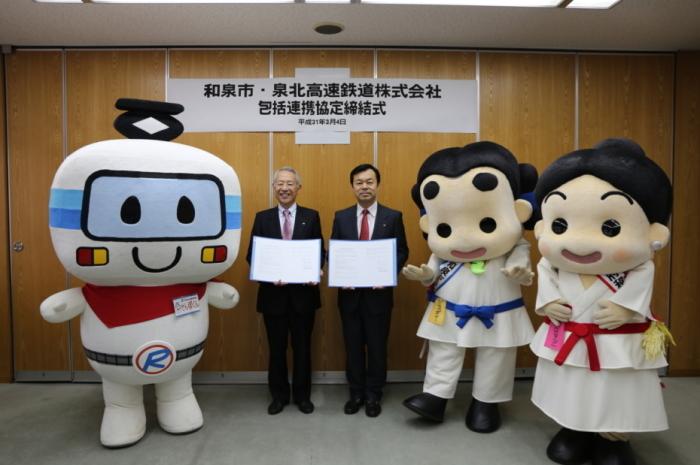 辻市長と福田代表取締役とそれぞれのイメージキャラクターと記念撮影