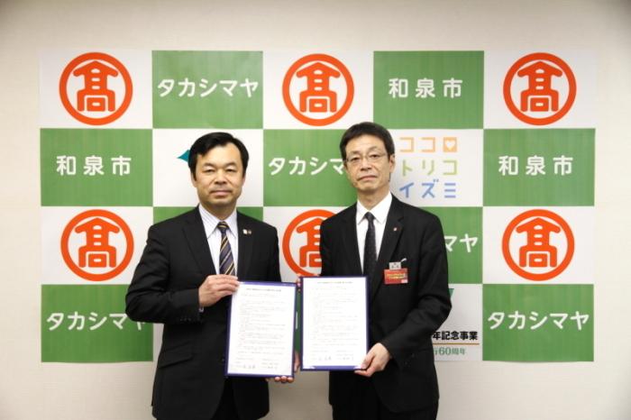 高島屋と和泉市長が協定書を両手で持ち、並んで写っている写真