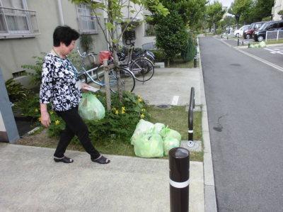 ごみ出し支援で預かったごみを回収場所に出しているおたがいさまサポーターの様子