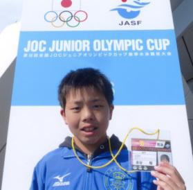 全国JOCジュニアオリンピックカップ春季水泳競技大会に出場した際の金谷駿さんがネームプレートを掲げている写真