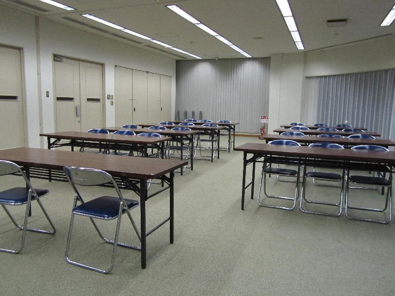 会議用テーブルやパイプ椅子が並んでいる会議室の写真