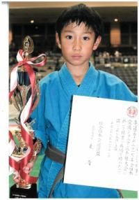 西日本地区交流試合において優勝し、会場にて授与された賞状とトロフィーを持つ奥山海晴さんの写真