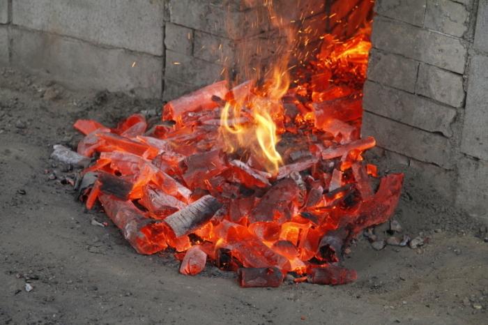 耐火煉瓦を使用した本格的な炭焼き窯の中で火が勢いよく燃え上がっている写真