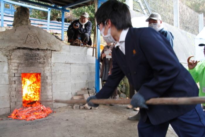 和泉市立南横山小学校の男子生徒が炭焼き体験を行っている様子の写真